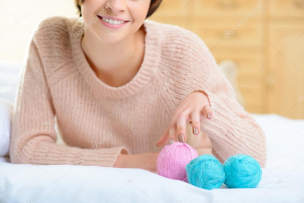 Young girl with wool yarn for knitting.
