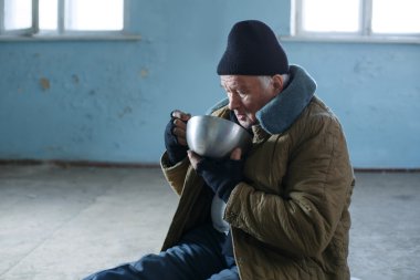 Eski yaşlı serseri onun demir kaseden yiyor.