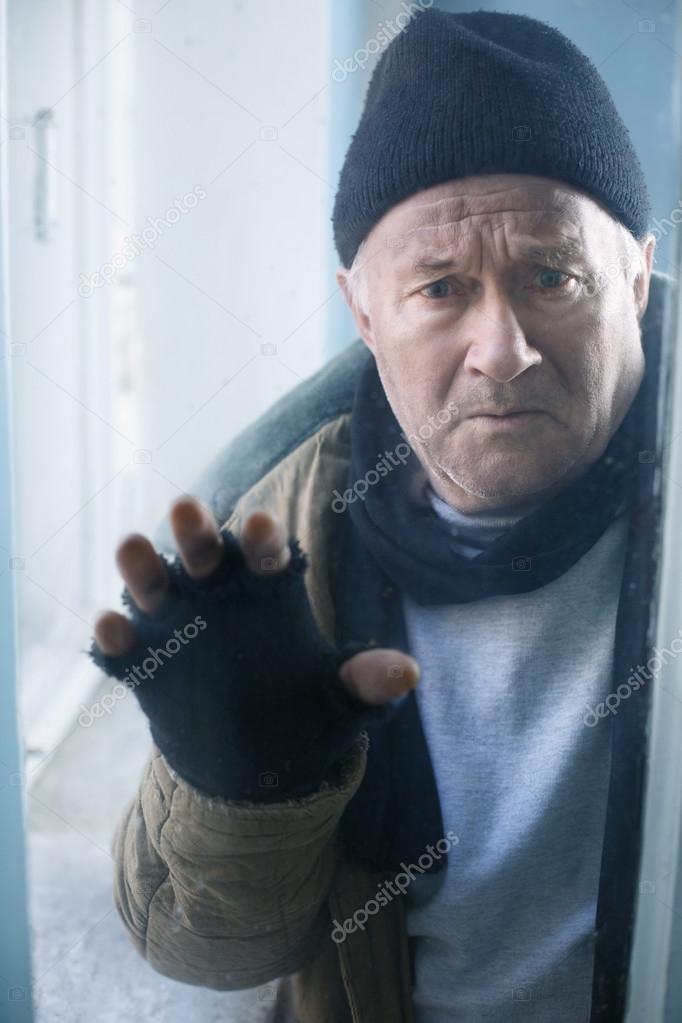Homeless man looks out of the window.