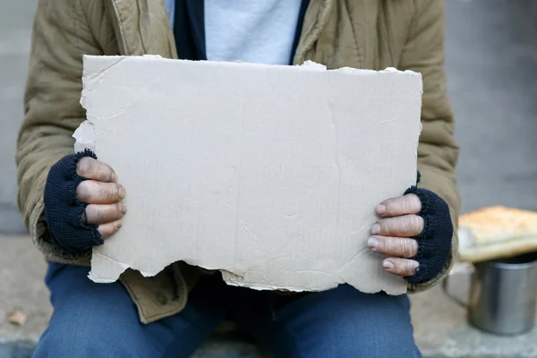 Homeless man holding a cardboard sign. — Stock Photo, Image