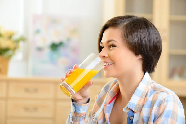 Молодая девушка пьет апельсиновый сок . — стоковое фото