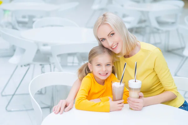 Feliz madre e hija sentadas en el café — Foto de Stock