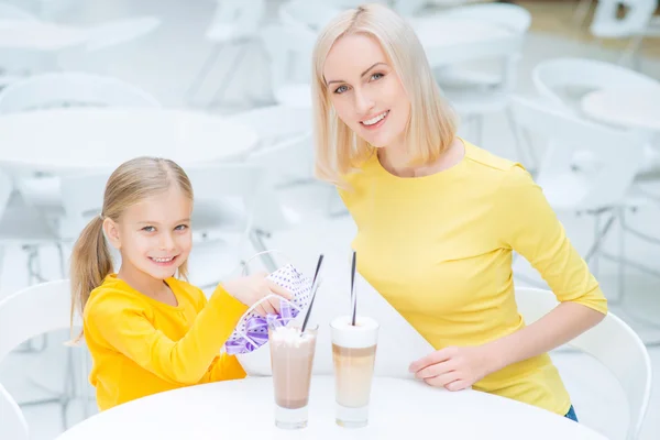 Feliz madre e hija sentadas en el café —  Fotos de Stock