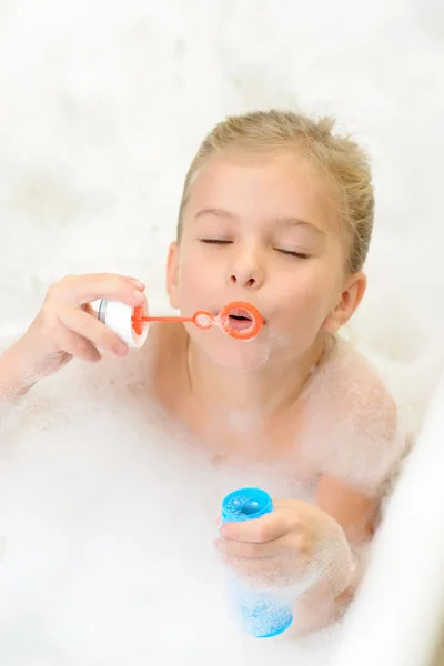 Pleasant little girl playing in bath tube — Stock Photo, Image
