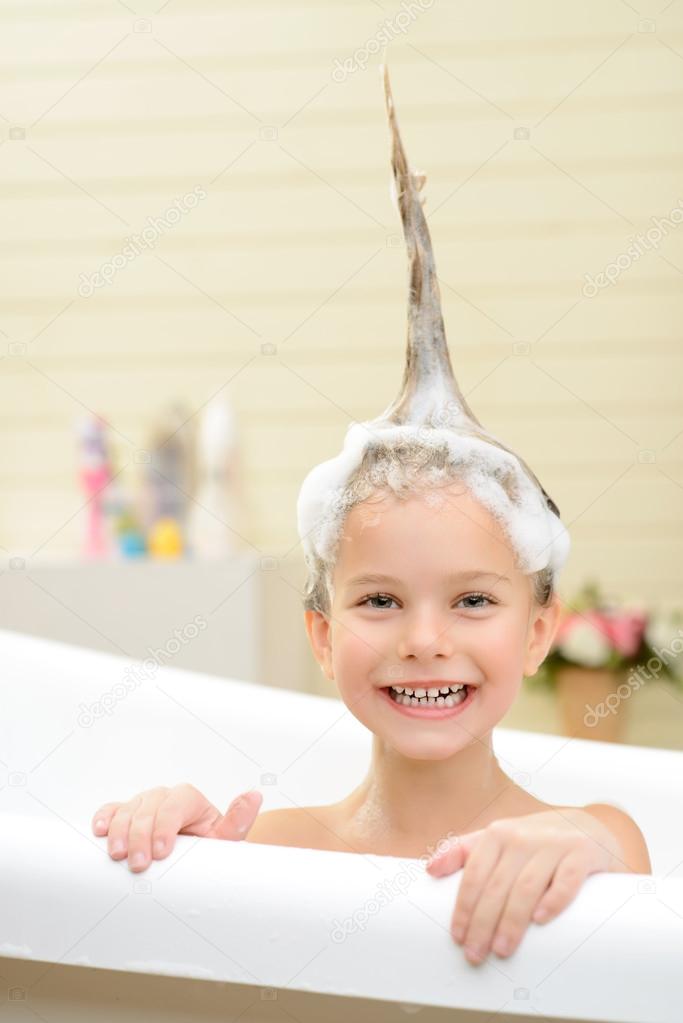 Cute little girl washing her hair