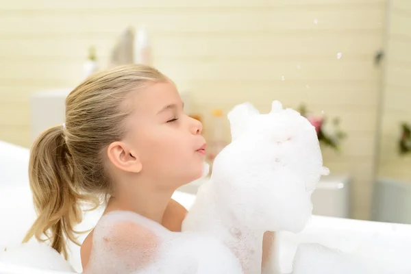 Pleasant little girl playing in bath tube — Stock Photo, Image