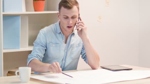 Junger Arbeiter ist mit der Überprüfung des Bauplans beschäftigt. — Stockvideo