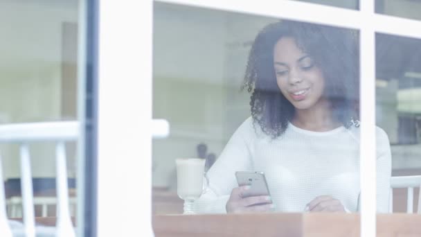 Woman in the cafe is texting on her phone. — Stok video