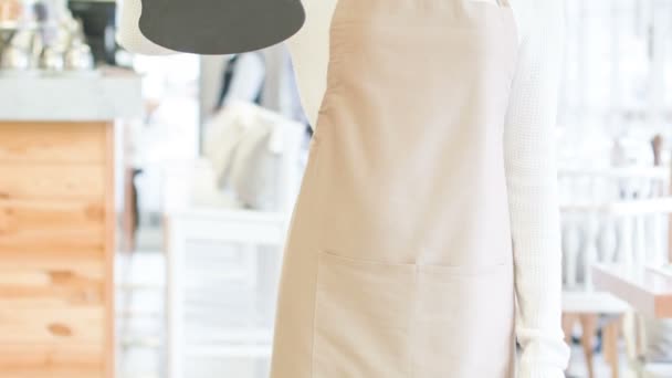 Smiling waitress holding an opening sign. — Stock Video