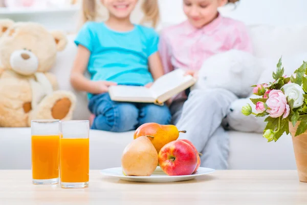 Fröhliche kleine Schwestern auf dem Sofa — Stockfoto