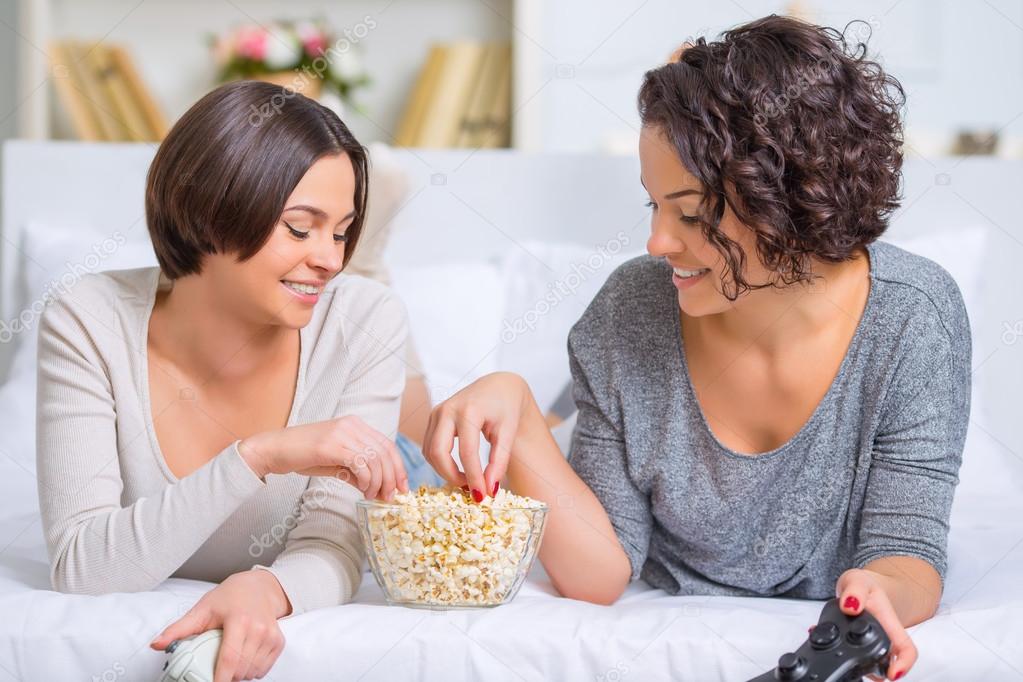 Sisters eating popcorn between videogames.