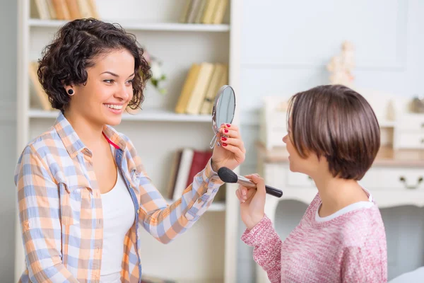 Uma irmã ajudando a outra com maquiagem . — Fotografia de Stock