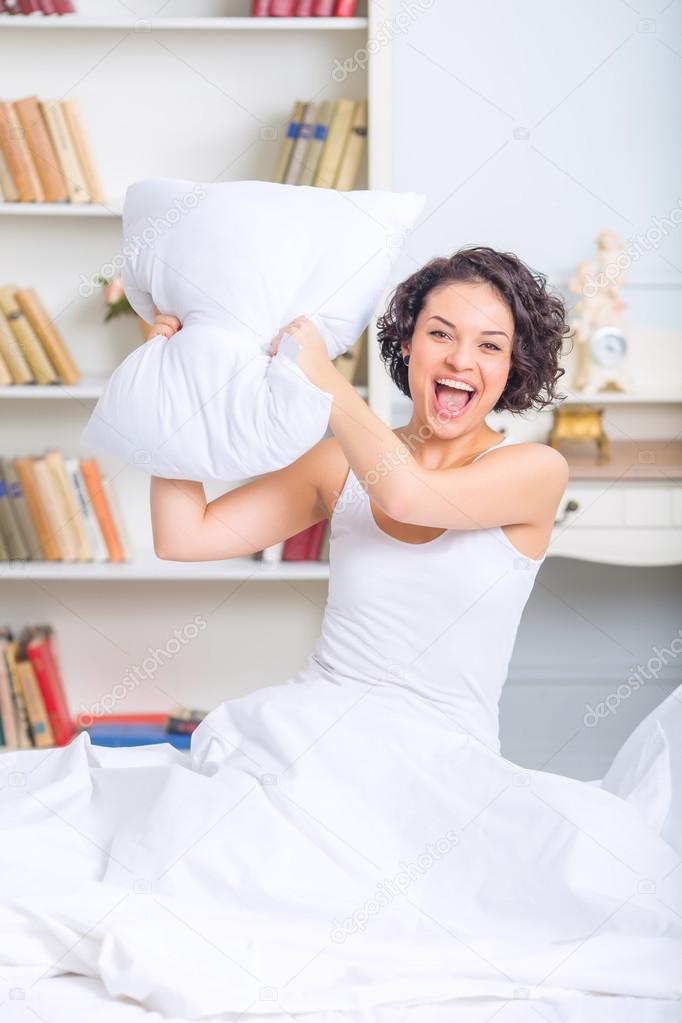 Young attractive girl during pillow fight.