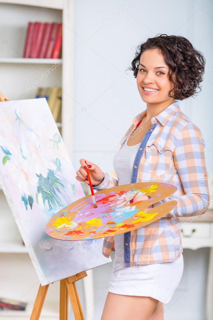 Young woman is painting a picture.