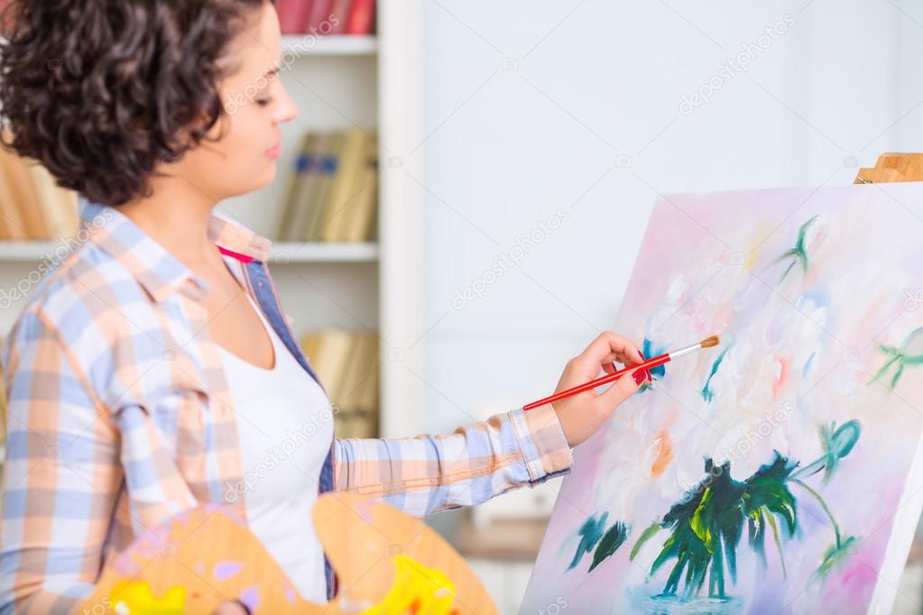 Young woman is painting a nature mort.