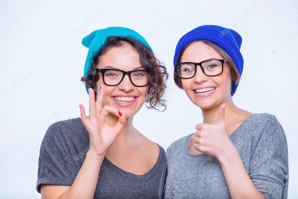 Two young cheerful sisters are posing together.