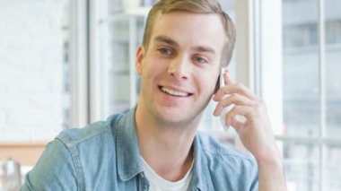 Yakışıklı adam telefonda canlı bir şekilde meşgul.