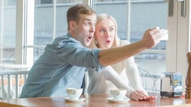 Genç çift selfies restoranda alıyor.