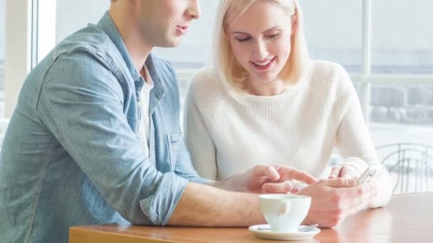 Pareja joven está discutiendo algo sobre el teléfono inteligente . — Vídeos de Stock