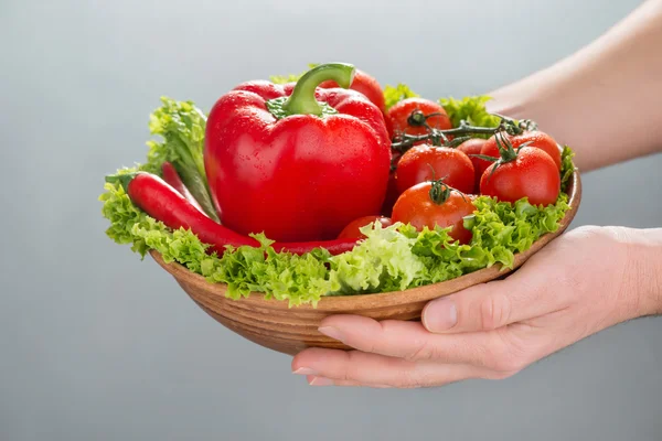 Person holding bowl with vegetables — Stock Photo, Image