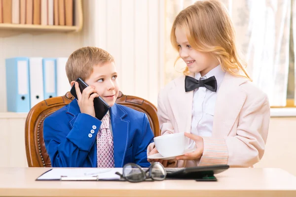 Menina com uma xícara e menino falando ao telefone . — Fotografia de Stock