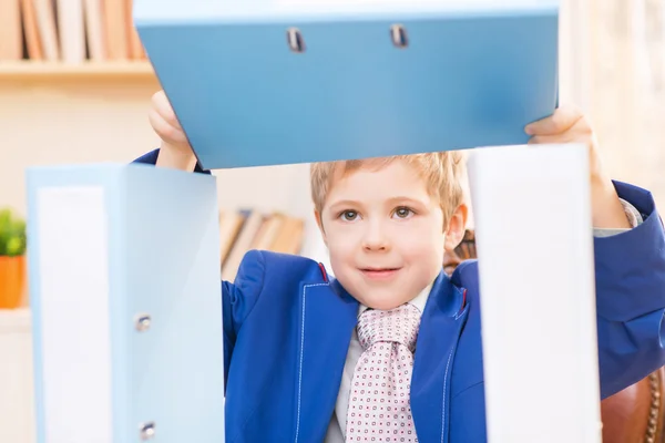 Little boy making figures out of folders. — Stock Photo, Image