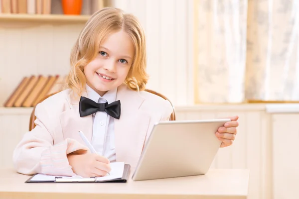 Menina escrevendo algo fora do tablet digital . — Fotografia de Stock