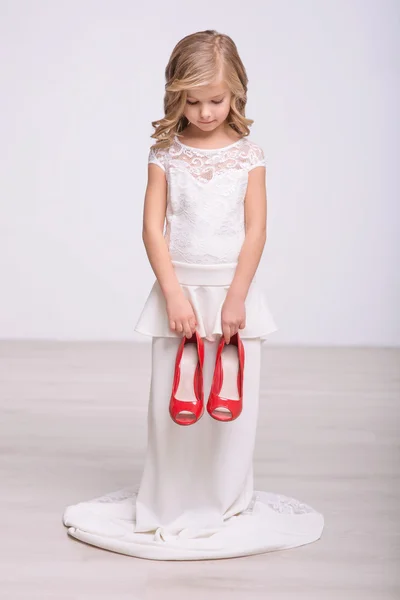 Kırmızı ayakkabılar holding neşeli küçük kız — Stok fotoğraf
