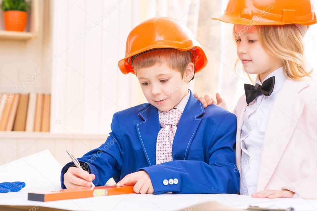 Little girl and boy are working with construction papers.