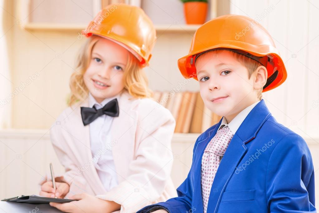 Little boy and girl are wearing protective helmets.