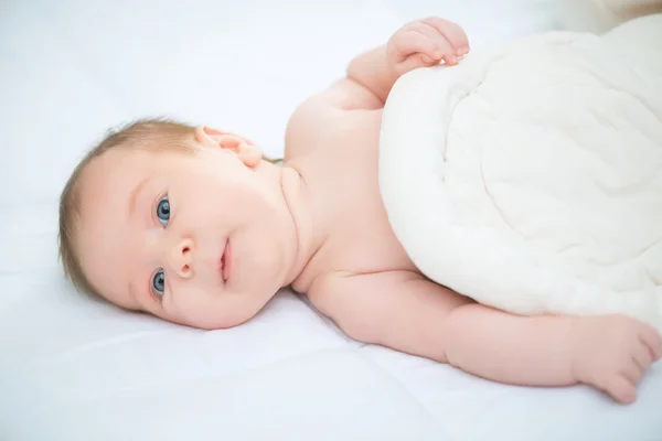 Bebê bonito deitado na cama — Fotografia de Stock