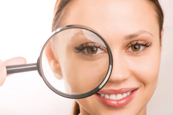 Young girl is holding a loupe at her eye. Stock Photo