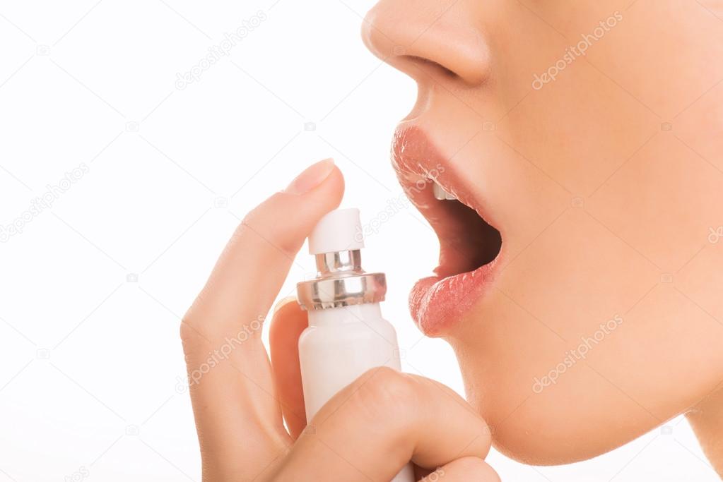 Young girl using breath freshener.