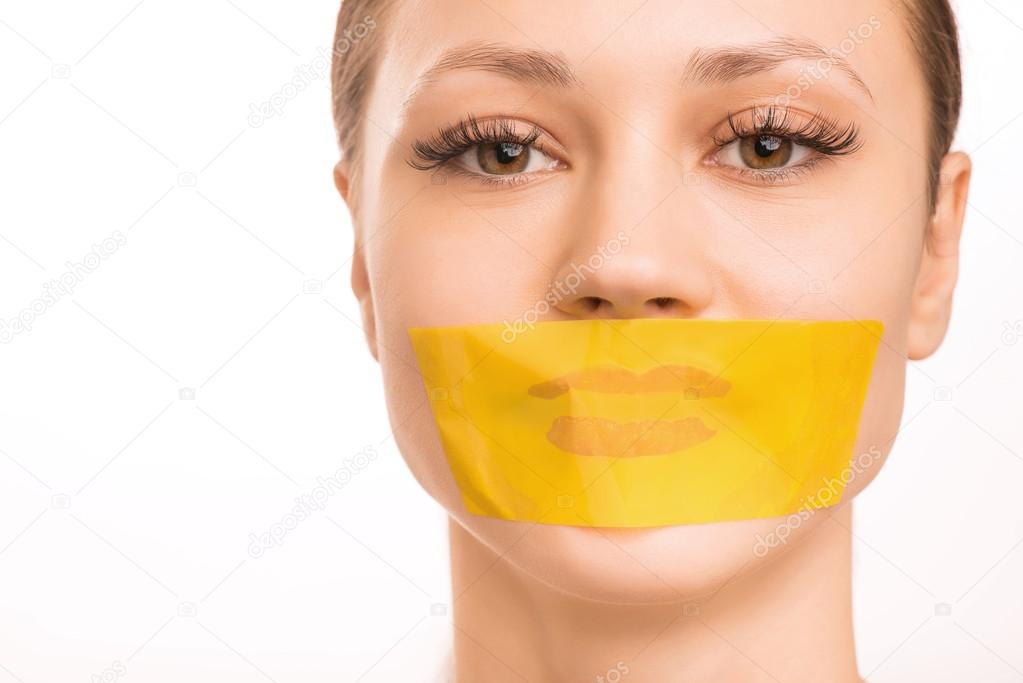 Young girl with her mouth taped.