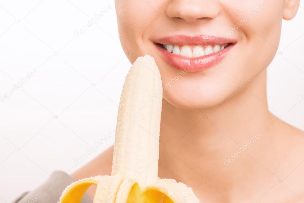 Young girl is about to eat a banana.