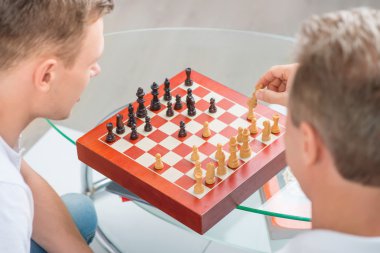 Father and his adult son playing chess