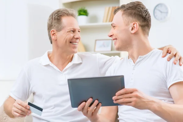 Father and adult son holding tablet — ストック写真