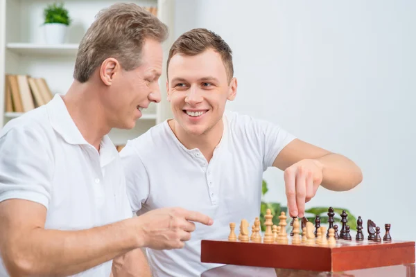 Отец и его взрослый сын играют в шахматы — стоковое фото