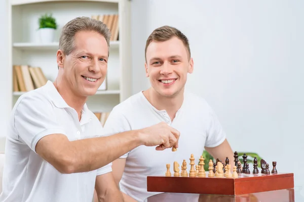 Батько і його дорослий син грають в шахи — стокове фото