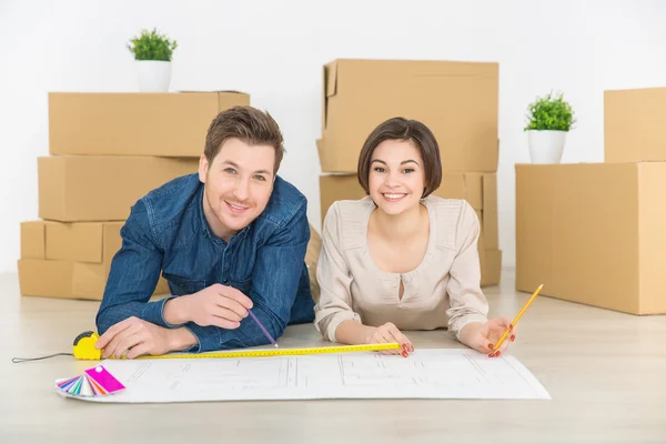 Happy couple drawing plan of their flat — Stock Photo, Image