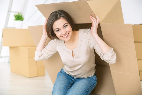 Pozitív bájos lány rejtőzik a doboz — Stock Fotó