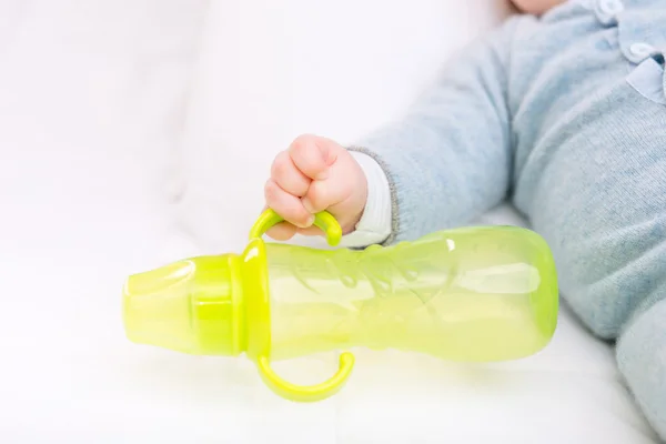 Infant boy grabbing a bottle. — Stock Photo, Image