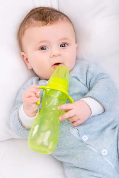 Infant boy holding his bottle. — Stock Photo, Image