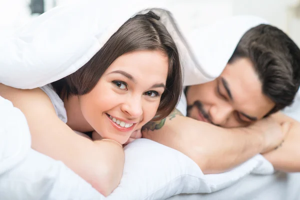 Bonita pareja amorosa tumbada en la cama — Foto de Stock