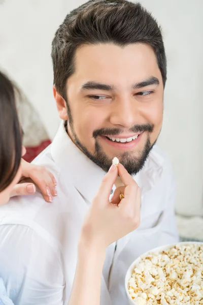 Женщина кормит мужа попкорном — стоковое фото