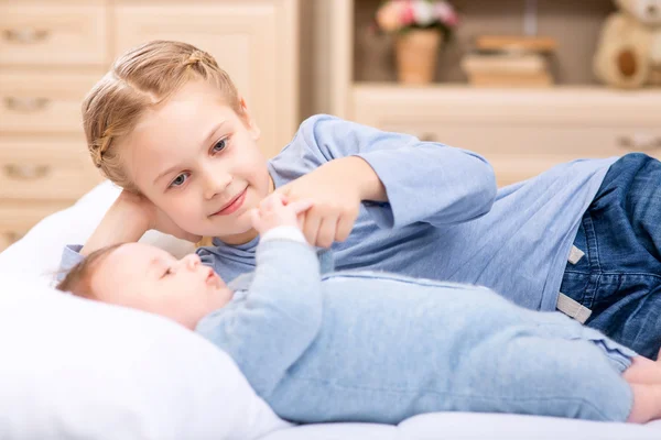 Little girl is playing with her tiny brother. — Stock Image Little girl is playing with her tiny brother. Royalty Free Stock Photos