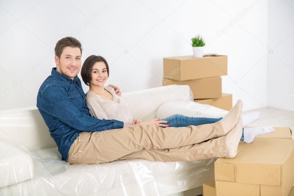Cheerful couple resting on the sofa