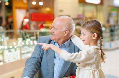 girl is showing something to her grandfather