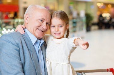 grandfather with granddaughter looking attentively.
