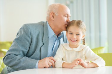 grandfather gently giving kisses granddaughter